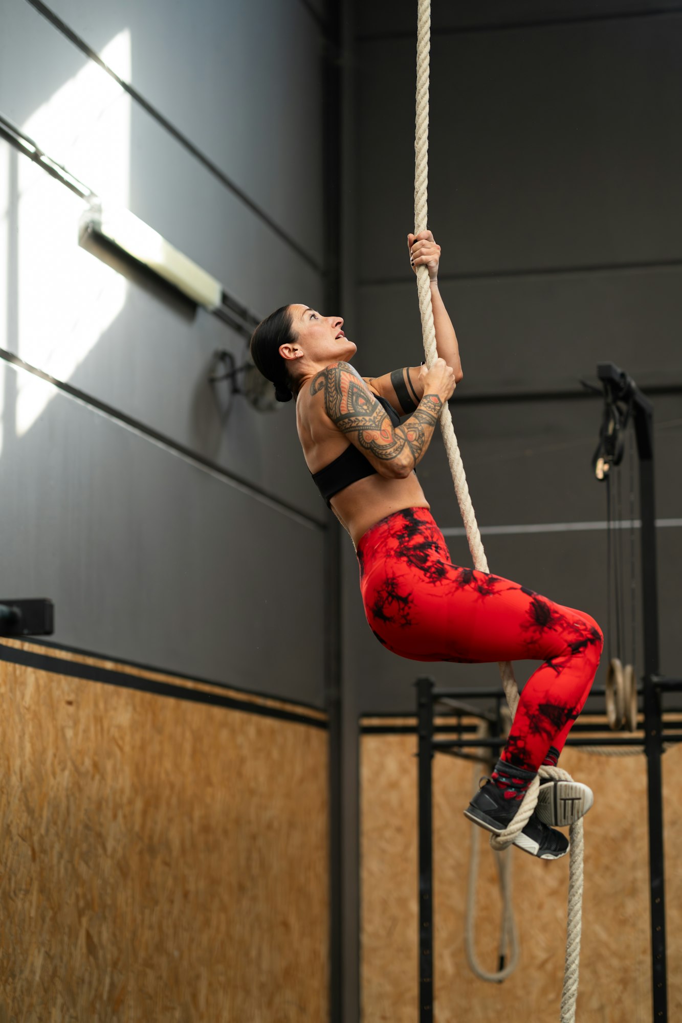 Sportive mature woman exercising with a rope in a gym